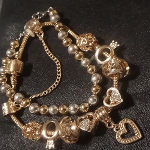 Gold tone charm bracelet & gold and silver beaded bracelet on a chain.